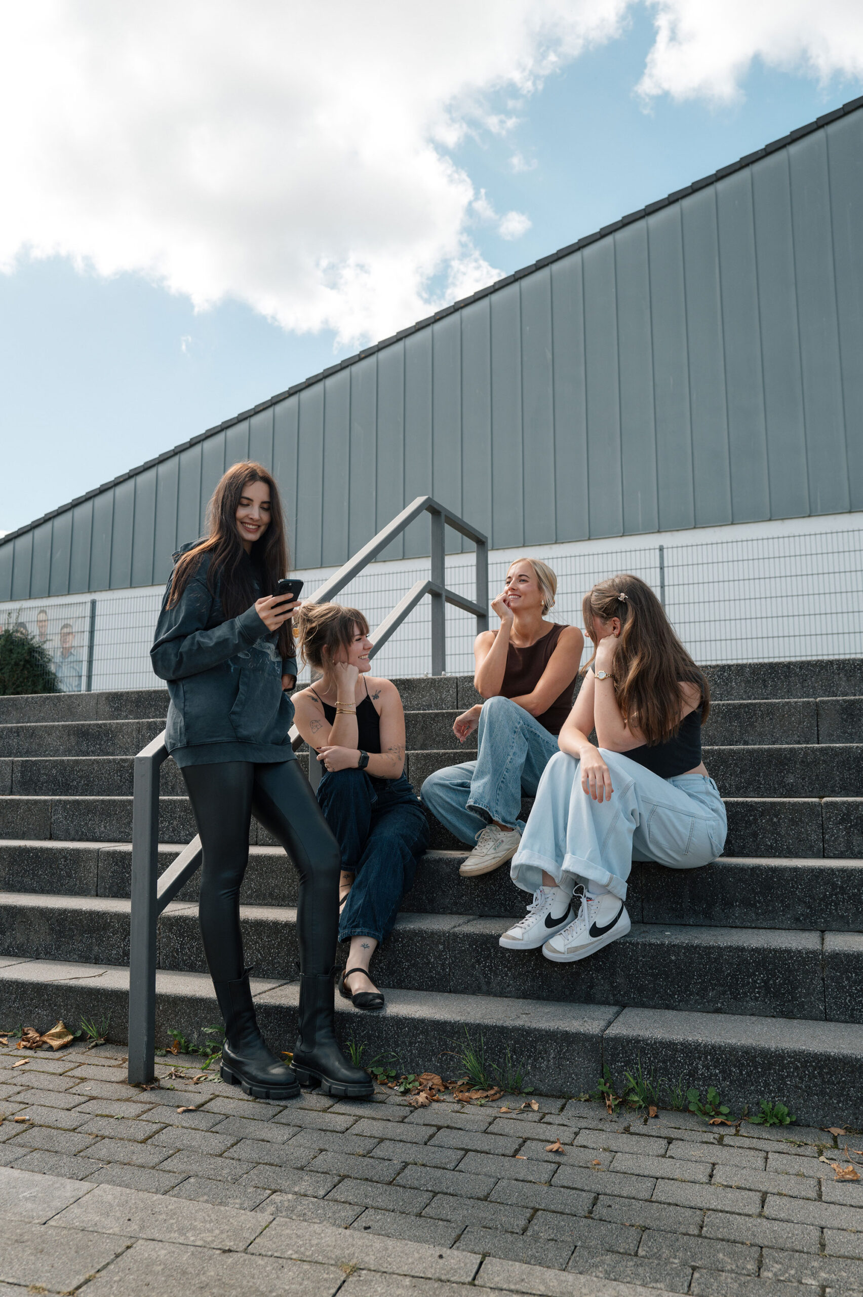 Anika, Ansprechpartnerin bei sevenpress, an einer roten Treppe