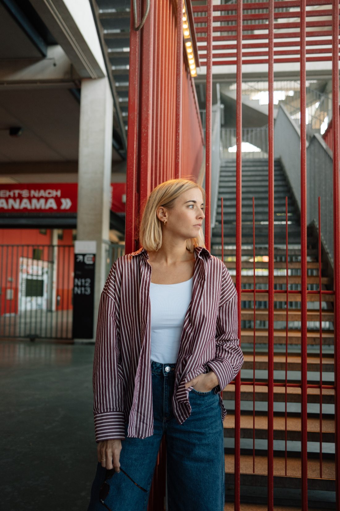 Anika, Ansprechpartnerin bei sevenpress, an einer roten Treppe